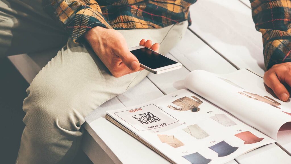 Barcode use case in advertising. QR code being scanned in a magazine.